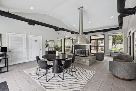 a living room with a table and chairs and a fireplace